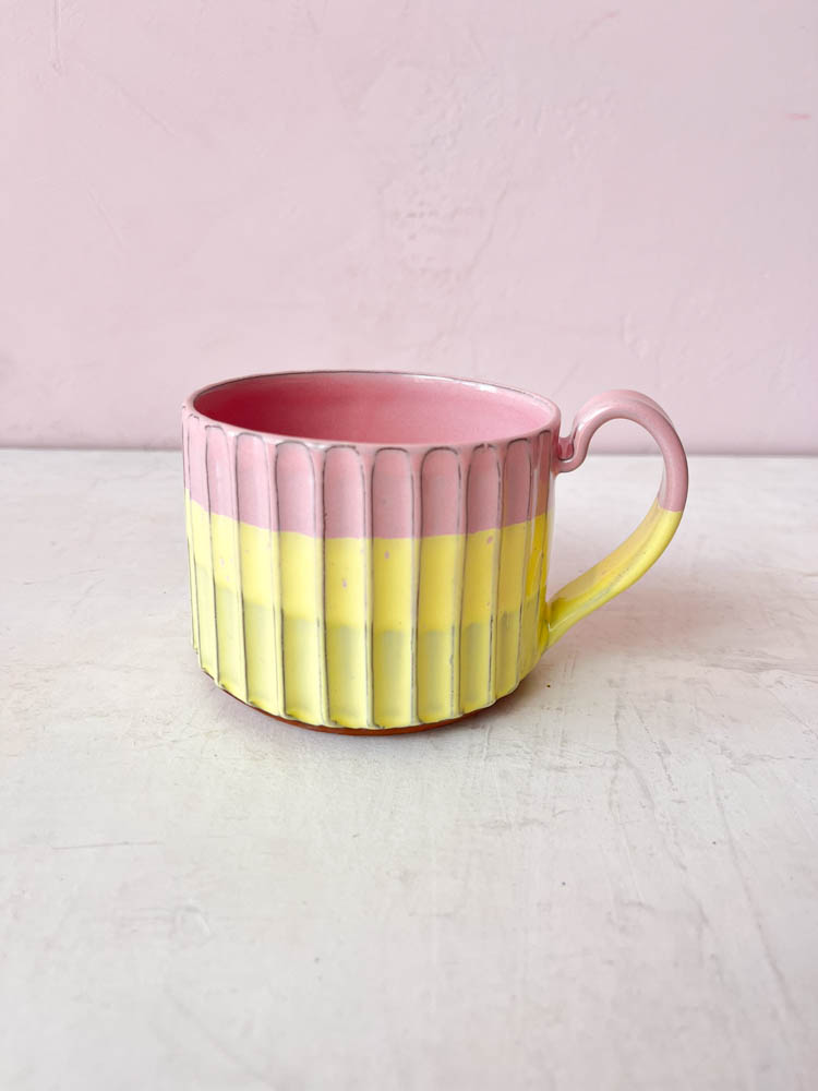 En mugg med handtag från Trine Lise keramik, gul och rosa