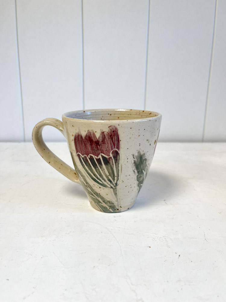 Kopp med handtag och blommotiv